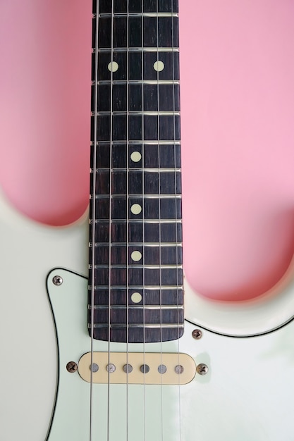 detail van elektrische gitaar op een roze oppervlak