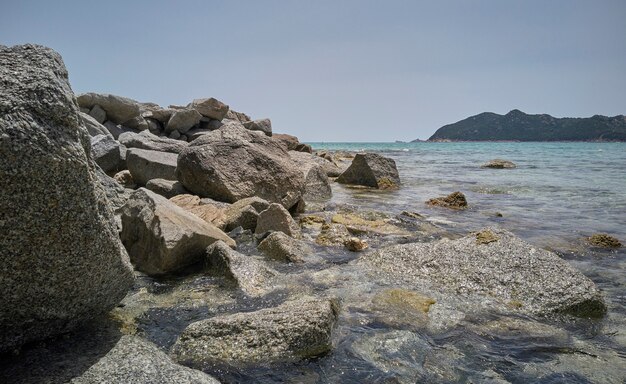 Detail van het kristalheldere water van de zee dat tegen de natuurlijke rotsen aan de kust crasht.