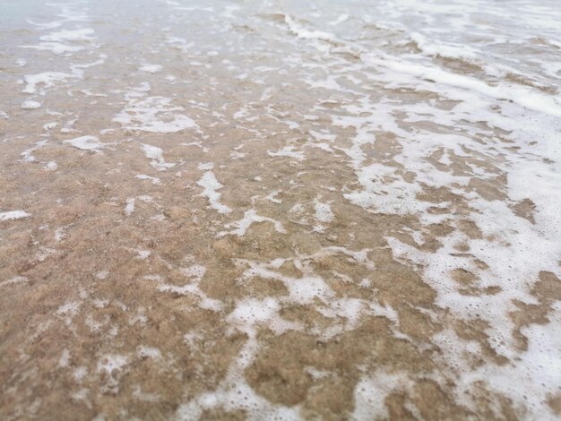 Detail van kleine golven die aankomen bij de kust van het strand. Ontspanning en rust