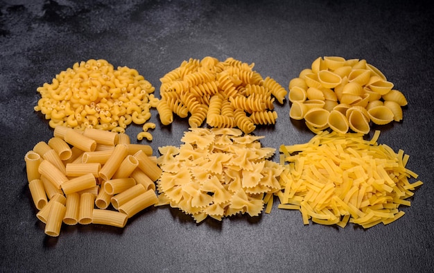 Detail van macaroni pasta nuttig als achtergrondstructuur droge pasta bovenaanzicht op zwarte achtergrond