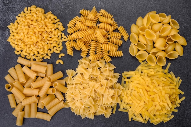 Detail van macaroni pasta nuttig als achtergrondstructuur droge pasta bovenaanzicht op zwarte achtergrond