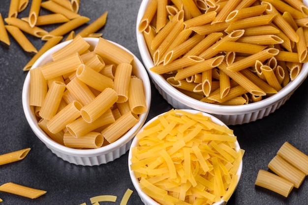 Detail van macaroni pasta nuttig als achtergrondstructuur Droge pasta Bovenaanzicht op zwarte achtergrond