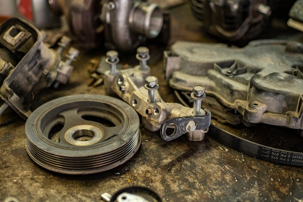 Detail van oude auto-onderdelen op een bankje in een werkplaats