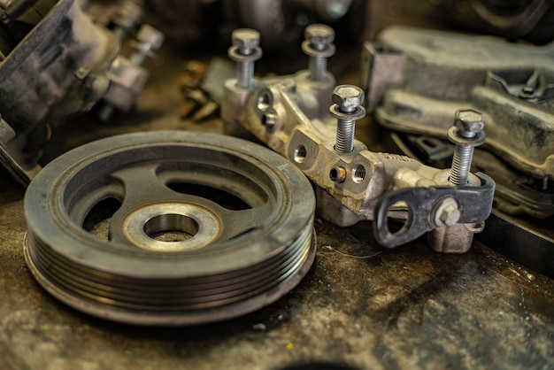 Detail van oude auto-onderdelen op een bankje in een werkplaats