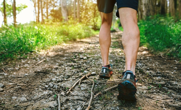 Detail van voeten van jonge man die deelneemt aan een trailrace door het bos the