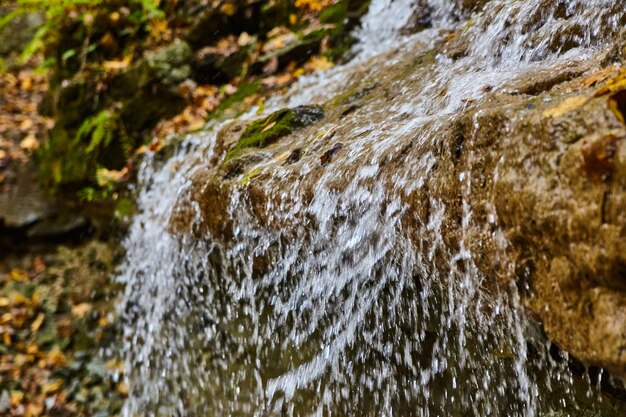 Detail van watervalwater dat over rand wazig stroomt