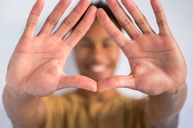 Detail van wijd open handen samen in de voorkant. Onherkenbare Afro-Amerikaanse man doet een driehoek teken vorm met de handen. Stop racisme en omarm verschillende etnische groepen.