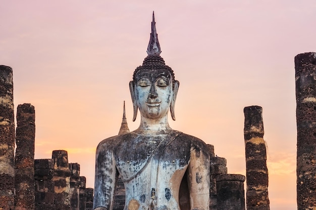 Detail van zittende Boeddha bij kleurrijke zonsondergang Sukhothai Thailand