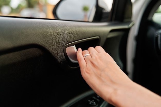 写真 車のドアを内側から開く女性の手の詳細図。