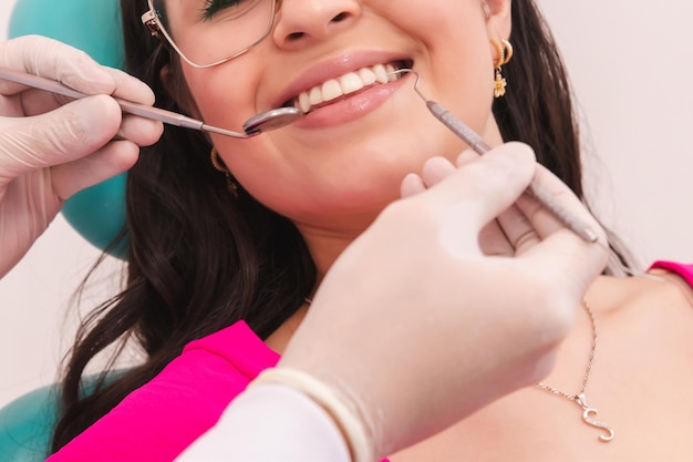 写真 女性患者の歯を処理する歯医者の手の詳細な写真