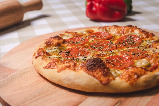 Detail view of personal pepperoni pizza on top of a table with a checkered tablecloth