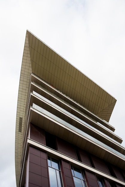 detail view of the top of a modern building. angular form design. abstract urban view with a sky. architecture with sharp angle.