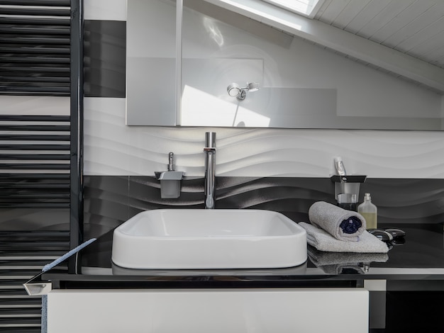 Detail of  a washbasin in the modern bathroom in foreground the steel faucet