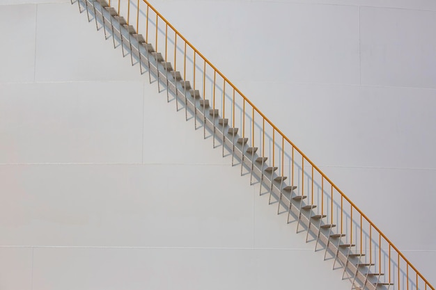 Detail of white tanks oil in tank farm with iron staircase