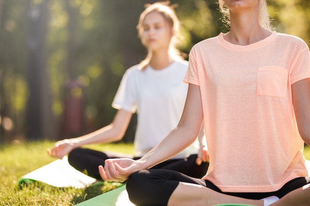 Detail of women doing yoga outdoors at sunrise. Morning meditation.