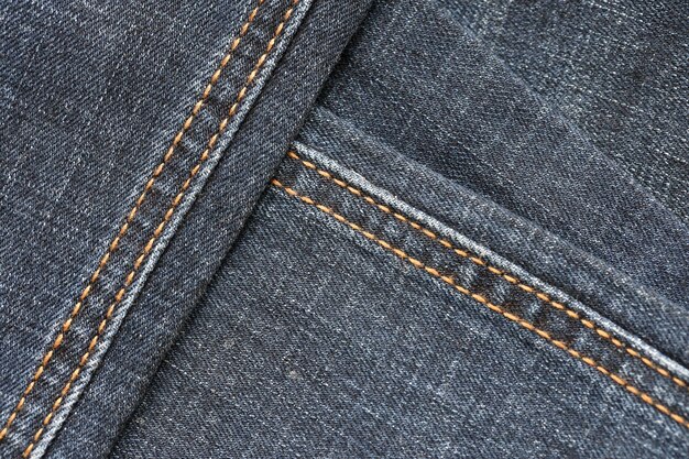 Detailed abstract texture of dark blue denim cloth Background image of old used denim trousers fabric