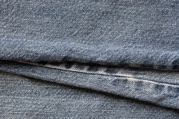 Detailed abstract texture of dark blue denim cloth Background image of old used denim trousers fabric