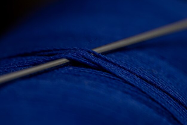 Detailed closeup shot of a needle in a blue thre