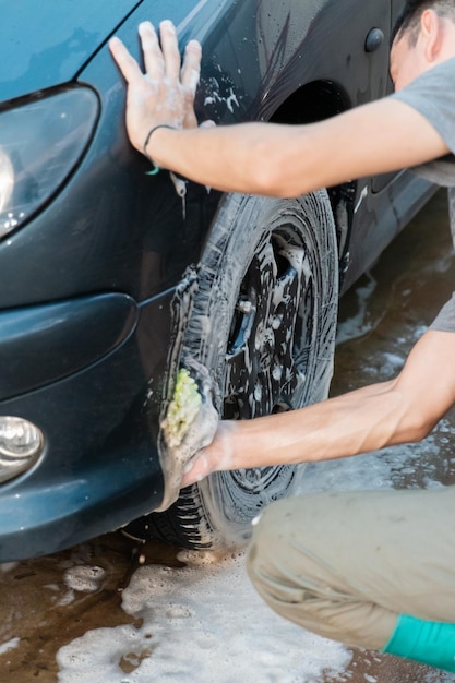 Detailed shot of a person washing the inside of a car's wheel fender