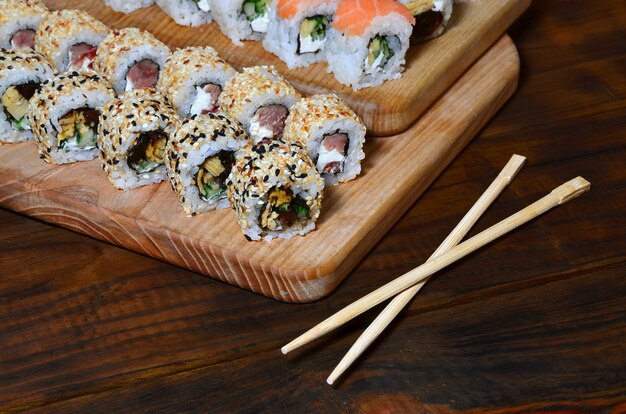 A detailed shot of a set of Japanese sushi rolls and a device for their use chopsticks