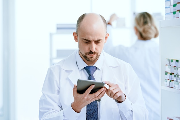 Detailopname. apotheker met behulp van een digitale tablet op zijn werkplek.