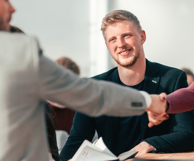 Detailopname. de gelukkige sollicitant die tijdens het sollicitatiegesprek de hand schudt van de werkgever