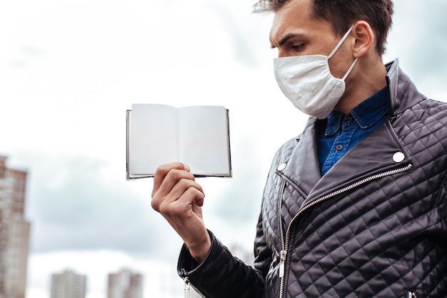 Detailopname. een man met een beschermend masker die zijn paspoort presenteert. foto met een kopie-ruimte