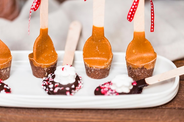 Foto detailopname. gezouten karamel warme cacao lepels op een wit dienblad.