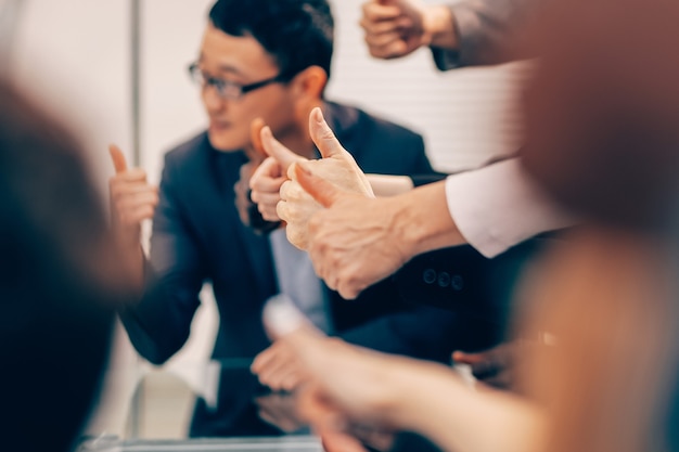 Detailopname. groep jonge zakenmensen die duimen opdagen. business achtergrond