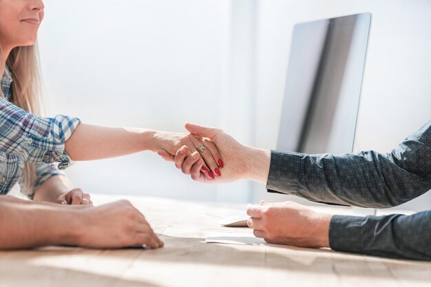 Foto detailopname. handdruk zakenpartners zitten aan de tafel. concept van partnerschap