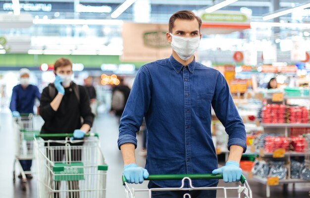 Detailopname. jonge man in een beschermend masker met een winkelwagentje