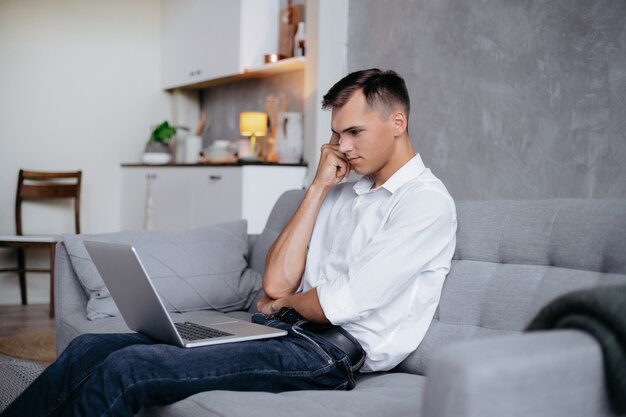 Detailopname. jonge man met zijn laptop in een gezellige woonkamer.