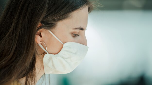 Detailopname. jonge vrouw met een beschermend masker. pandemie in de stad