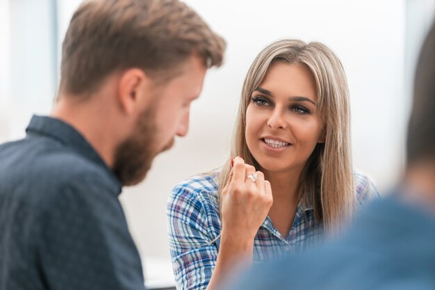 Detailopname. jonge zakenvrouw en haar collega's tijdens een bijeenkomst op kantoor.