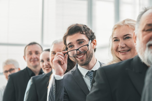 Detailopname. lachende zakenman die op een rij staat met zijn collega's