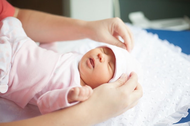 Detailopname. moeder corrigeert de dop, haar pasgeboren baby. het concept van het moederschap