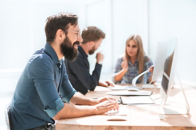 Detailopname. zakenman en een groep werknemers die op kantoor werken.