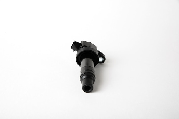 Details of the car ignition system a new ignition coil on a white isolated background