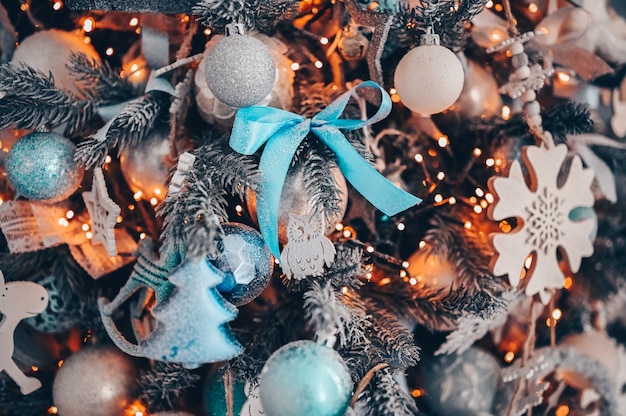 Details of a Christmas decorated tree in dark turquoise and orange colors