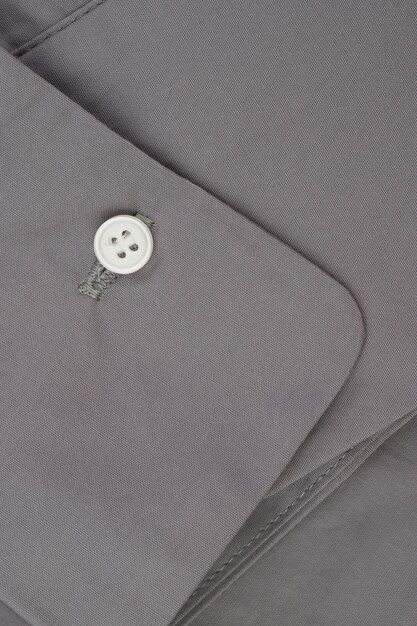 Dettagli delle chiusure e cuciture di una camicia da donna realizzata in tessuto di cotone grigio