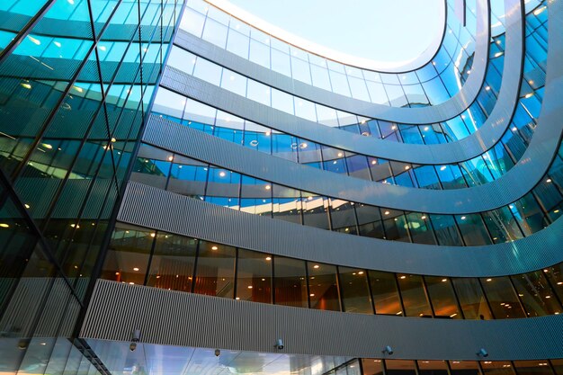 Dettagli dell'architettura futuristica del moderno grattacielo in metallo e vetro che riflette il cielo blu