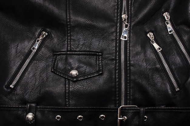 Details of a leather jacket with a clasp, rivets and pockets