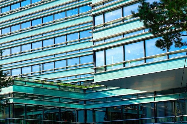 Details of modern architecture of steel and glass skyscraper reflecting the blue sky