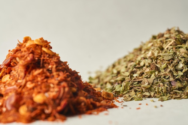 Details of a mountain of oregano and ground chili on a white background