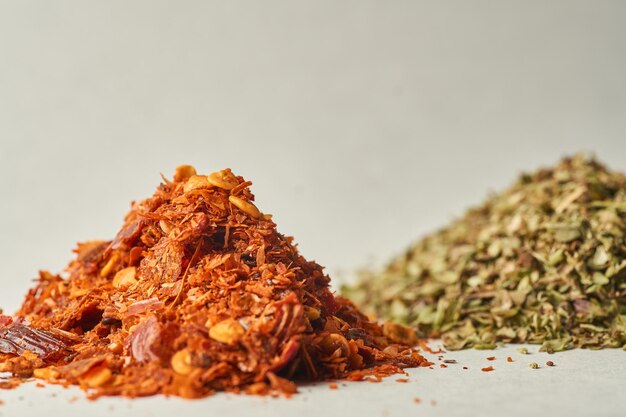 Details of a mountain of oregano and ground chili on a white background