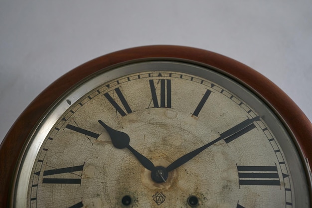 Details of an old clock on white wall