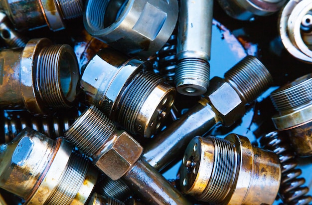 Details of the ship's main engine in oil closeup Nozzles bushings springs and threaded parts