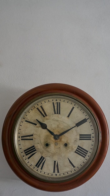 Details van een oude klok op witte muur