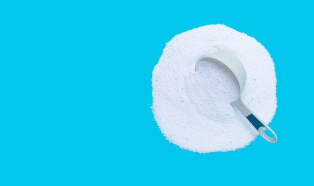 Photo detergent powder with measuring spoon for clothes washing. laundry concept.