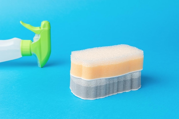 Detergent and two foam sponges on a blue background